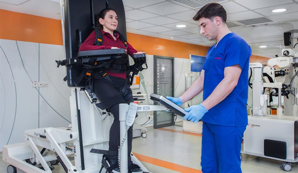 Erigo Pro Robotik Yatak teknolojisi hastanın kontrollü bir şekilde dik pozisyona getirilmesini ve robotik teçhizatları ile pasif bir şekilde felçten sonra yürümek sağlanabilir.