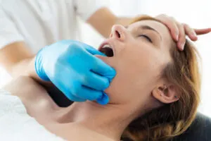 Çene Ağrısı Neden Olur? Nasıl Tedavi Edilir? – young physiotherapist doing a face treatment to th 2024 02 23 05 03 36 utc